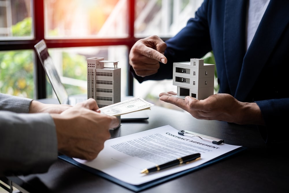 Real,Estate,Agent,Holding,Hands,To,Client,To,Sign,Agreement